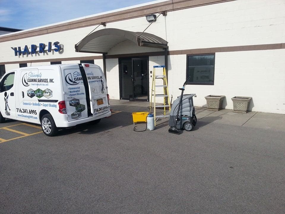 A Steinmetz Cleaning Services van and floor equipment outside a Western New York commercial building at the start of a job