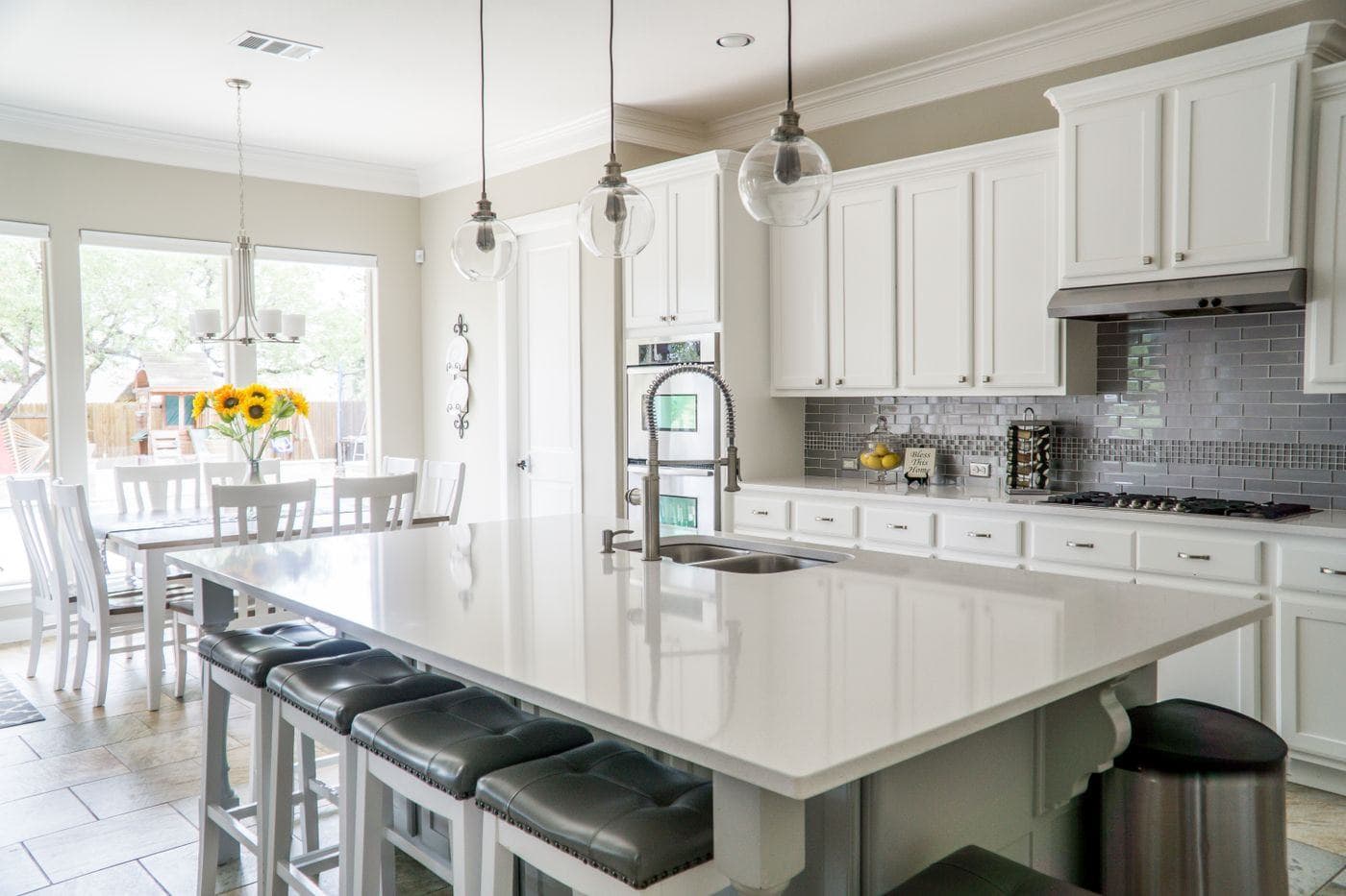 A bright kitchen with a white island and clear counter tops after a residential clean